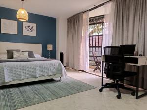 1 dormitorio con cama, escritorio y silla en Acogedor apartaestudio ubicado en Laureles, en Medellín