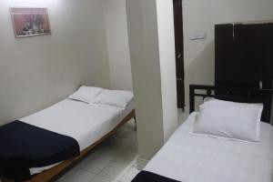 two beds in a small room withermottermottermott at Hotel Grand Amir International in Dhaka