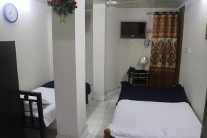 Cette petite chambre comprend un lit et une télévision. dans l'établissement Hotel Grand Amir International, à Dhaka