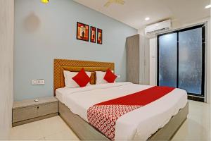 a bedroom with a large bed and a window at OYO Hotel Green Signature in Surat