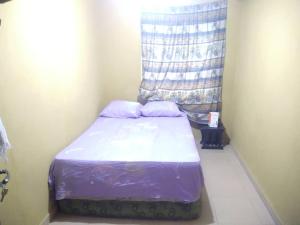 ein kleines Bett in einem Zimmer mit Fenster in der Unterkunft Two bedroom Home at Gbagi, New Ife Road, Ibadan @ Igbekele Oluwa House, 3 Zone A, Opeyemi Street, New Gbagi Market, New Ife Road, Gbagi, Ibadan, Oyo State in Ibadan