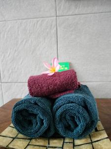 uma pilha de toalhas com uma flor em cima delas em The Gana Ubud by Guru experience em Ubud
