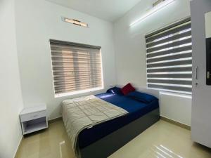 a bedroom with a bed and two windows at starhive in Kalpetta