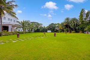 a large grassy field in front of a white building at Palette - Hotel Bon Sejour in Pondicherry