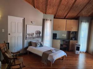 a bedroom with a large bed and a kitchen at Grobler's Haven Self catering cottage in Pretoria
