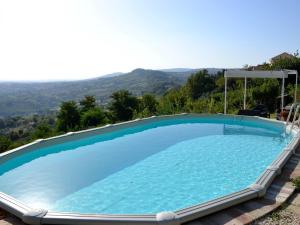 una grande piscina con una montagna sullo sfondo di Tranquil Apartment in Cupramontana with Garden a Cupramontana