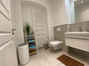 ein weißes Bad mit einem WC und einem Waschbecken in der Unterkunft Ferienwohnung Lipsia in Leipzig