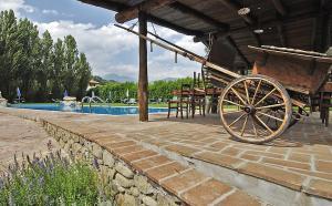 a wooden cart sitting next to a swimming pool at Venturo Agriturismo Restaurant & Horses in Castelnuovo di Garfagnana