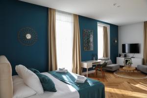 ein blaues Schlafzimmer mit einem Bett und einem Wohnzimmer in der Unterkunft Hôtel Les Séquoias in Ruy