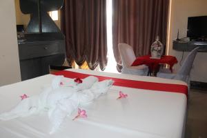 a bedroom with a bed with pink decorations on it at LORELEI BEACH RESORT in Gate