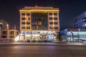 ein großes Gebäude mit nachts davor geparkt in der Unterkunft Dar Hotel Suites in Dschidda