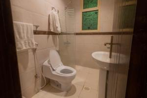 ein Bad mit einem WC und einem Waschbecken in der Unterkunft Dar Hotel Suites in Dschidda