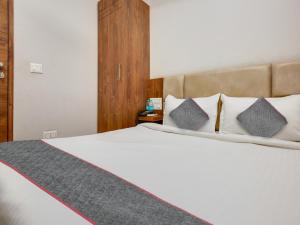 a bedroom with a large white bed with pillows at Hotel Ludhiana Regency in Ludhiana