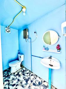 Baño azul con aseo y lavamanos en Monteadeo Camping, en Mon Jam