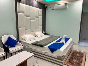 a bedroom with a bed with blue sheets and two chairs at I Light Beach Resort in Mandarmoni