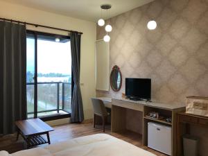 a hotel room with a desk with a computer and a window at 花蓮太平洋會館民宿 in Jian