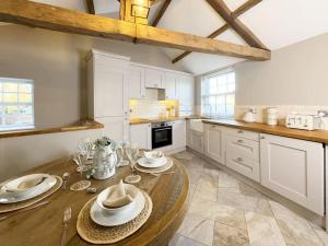 una cocina con una mesa de madera con platos. en Whitkirk Cottage en Leeds