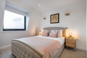 a bedroom with a large bed with pink pillows at Farringdon/St Pancras penthouse in London
