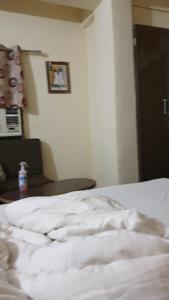 AshoknagarにあるHotel Adhiraj Regency, Ashoknagarのベッドルーム(テーブル付)の白いベッド1台