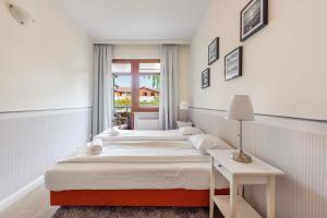 a bedroom with two beds and a table and a window at Meiguan with huge Terrace + extra 2 parking spots in Gdańsk