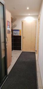 un pasillo con puerta y alfombra negra en Ferienwohnung umemma, en Kappl