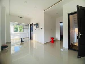 a large white room with a red vase on the floor at starhive in Kalpetta