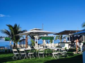 a table and chairs with umbrellas and the ocean at Seaview Emerald Adoces Beach Resort in Morong