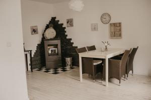 a dining room with a table and a clock on the wall at Häserhof Gästehaus & Stall-Loft in Raddestorf