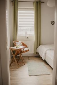 Schlafzimmer mit einem Bett, einem Tisch und einem Fenster in der Unterkunft Ferienwohnung Häserhof in Raddestorf