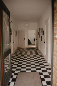 un pasillo con suelo a cuadros en blanco y negro en Ferienwohnung Häserhof, en Raddestorf