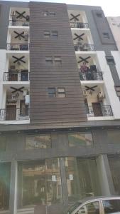 a tall building with several balconies with x at Travellers Heaven 3BR APT DHA PHASE VI in Karachi