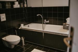 ein Badezimmer mit einem WC und einer Badewanne in der Unterkunft Ferienwohnung Häserhof in Raddestorf