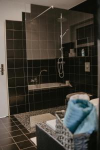 y baño con ducha, lavabo y bañera. en Ferienwohnung Häserhof, en Raddestorf