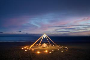 una marquesina en la playa por la noche con luces en Kantary Beach Hotel Villas & Suites, en Khao Lak