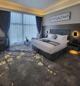 um quarto de hotel com uma cama grande e janelas em Msharef almoden hotel فندق مشارف المدن em Riyadh