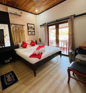 a bedroom with a bed with two stuffed animals on it at Singrarat Hotel in Luang Prabang