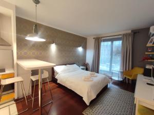 sypialnia z łóżkiem, stołem i oknem w obiekcie JM Apartment Old Town Krakow w Krakowie