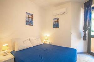 Cette chambre blanche dispose d'un lit bleu et d'une fenêtre. dans l'établissement Viviana, à Campese