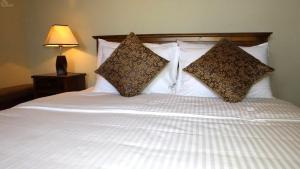 ein Bett mit zwei Kissen darüber in der Unterkunft Villa Arunalu Kandy in Kandy