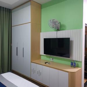 un salon avec une télévision et une armoire blanche dans l'établissement QV Manor Hotel, à Phan Rang