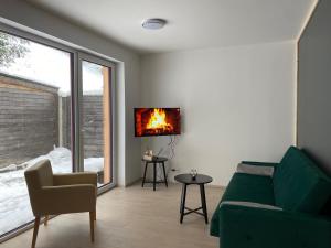 a living room with a couch and a fire on the wall at Apartmány Pstruží AP19 in Pstruží