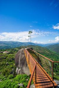 a boardwalk on top of a mountain with a tree at Pura Vida Matos House in Fafião