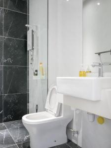 La salle de bains blanche est pourvue de toilettes et d'un lavabo. dans l'établissement Beacon Executive Suite by Uptrend Home Management, à George Town