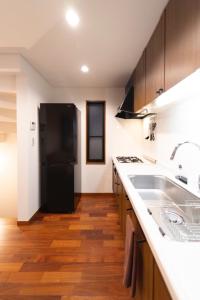 a kitchen with a black refrigerator and wooden floors at Minato-ku - House - Vacation STAY 14528 in Tokyo