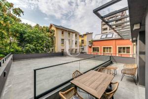 a patio with a wooden table and chairs on a balcony at Oslo: A modern furnished apartment with parking in Sofia