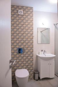 a bathroom with a toilet and a sink at Oslo: A modern furnished apartment with parking in Sofia
