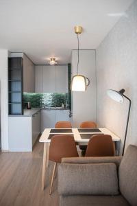 een woonkamer met een tafel en stoelen en een keuken bij Oslo: A modern furnished apartment with parking in Sofia
