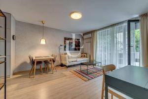 a living room with a table and a couch at Oslo: A modern furnished apartment with parking in Sofia