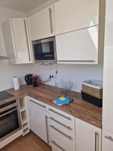 Una cocina con gabinetes blancos y una encimera de madera. en Apartment am Stadtrand zu Graz, en Graz 7 fotos más