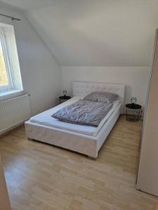 Un dormitorio con una cama en una habitación blanca. en Apartment am Stadtrand zu Graz, en Graz